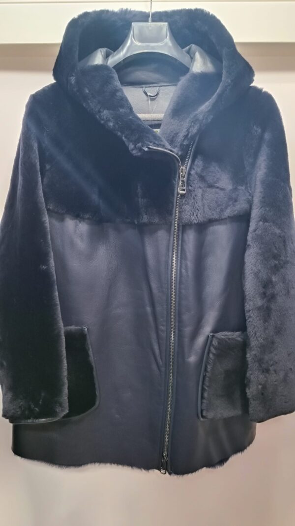 Дамски олекотен кожух от ГОЯ Leather. Нов модел, изключително лек дамски кожух с права кройка стил оверсайз .Изработен е от агнешка тула с покритие напалан, предпазващо от влага. Моделът е с прикачени външни джобове и неподвижна качулка. Страничните ципове на кожуха подсилват комфорта при носене. Кожух с модерна визия, лек и комфортен за носене.