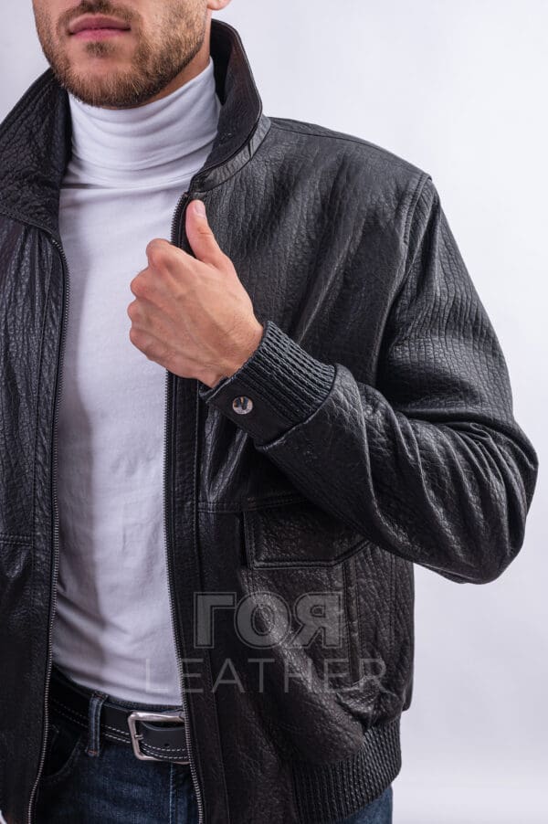 Мъжкото яке от естествена агнешка кожа в черен цвят VK- E 290 ще ви помогне да създадете своя ненадминат уникален стил. Един от най-популярните модели мъжки якета от естествена кожа. Подобни модели с различни дизайнерски опции са включени във всяка нова колекция. Късо кожено яке в стил бомбър. Кожен ластик на ханша  и маншетите. Затваряне с цип. В предната част има традиционни джобове с капак. Два джоба от вътрешната част Много удобен, атрактивен модел е ушит от висококачествена естествена агнешка кожа. Тя е мека и еластична, има характерен релеф и блясък. Издръжлива, без мирис, лесна за почистване. . Яката тип риза внася класика и собствена „жизненост“ във визията. Но при ветровито време може да се повдигне за по-голям комфорт.