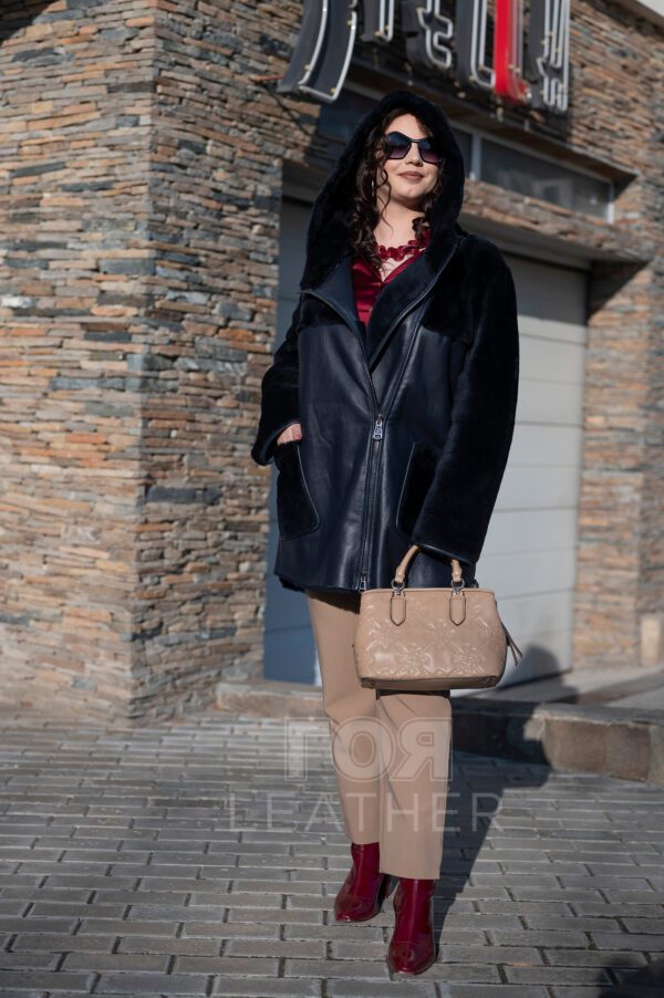 Дамски олекотен кожух от ГОЯ Leather. Нов модел, изключително лек дамски кожух с права кройка стил оверсайз. Изработен е от агнешка тула с покритие напалан, предпазващо от влага. Моделът е с прикачени външни джобове и неподвижна качулка. Страничните ципове на кожуха подсилват комфорта при носене. Кожух с модерна визия, лек и комфортен за носене.