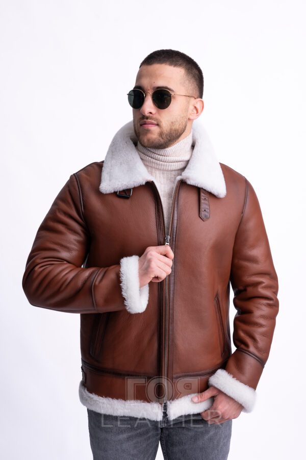 Мъжки авиаторски кожух от ГОЯ Leather. Мъжки модел, в класическа кройка и цвят за авиаторски кожух. Камел цвят на лицевата страна, бял косъм отвътре и типичните аксесоари за модела. Това е кожух, неподвластен на времето, предпочитан от мъжете заради лесното съчетаване с облеклото в ежедневието. Лек, топъл и комфортен, този модел е чудесен избор за студени зимни дни!