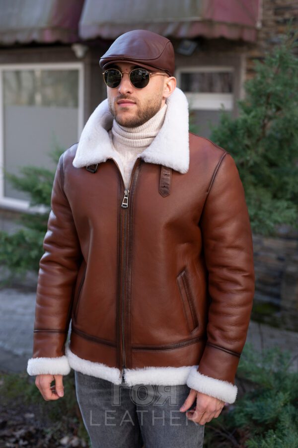 Мъжки авиаторски кожух от ГОЯ Leather. Мъжки модел, в класическа кройка и цвят за авиаторски кожух. Камел цвят на лицевата страна, бял косъм отвътре и типичните аксесоари за модела. Това е кожух, неподвластен на времето, предпочитан от мъжете заради лесното съчетаване с облеклото в ежедневието. Лек, топъл и комфортен, този модел е чудесен избор за студени зимни дни!