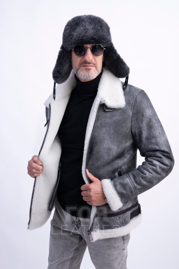 VK- N 85 | ЦВЯТ: Сив Мъжки авиаторски кожух от ГОЯ Leather.  Това е кожух, неподвластен на времето, предпочитан от мъжете заради лесното съчетаване с облеклото в ежедневието. Лек, топъл и комфортен, този модел е чудесен избор за студени зимни дни! Изработен от естествена агнешка  кожа с покритие, този модел не само се отличава със стилен външен вид, но и предлага отлични защитни свойства. Този кожух се съчетава перфектно както с класически, така и с по-спортни дрехи, което го прави универсална дреха. Не пропускайте възможността да добавите този стилен и практичен модел към гардероба си, който ще подчертае вашата индивидуалност и ще осигури комфорт при всяко време. Палтото от овча кожа се закопчава с цип по цялата дължина (70 см). Простият, прав силует на кожуха е допълнен от дизайнерски акценти под формата на контрастни кожени елементи и метални катарами в авиаторски стил.