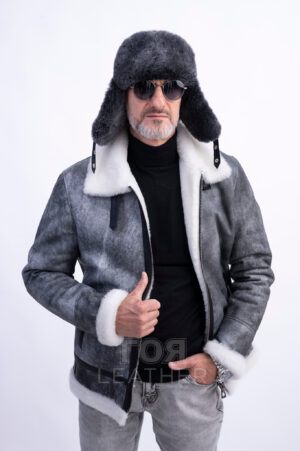 VK- N 85 | ЦВЯТ: Сив Мъжки авиаторски кожух от ГОЯ Leather.  Това е кожух, неподвластен на времето, предпочитан от мъжете заради лесното съчетаване с облеклото в ежедневието. Лек, топъл и комфортен, този модел е чудесен избор за студени зимни дни! Изработен от естествена агнешка  кожа с покритие, този модел не само се отличава със стилен външен вид, но и предлага отлични защитни свойства. Този кожух се съчетава перфектно както с класически, така и с по-спортни дрехи, което го прави универсална дреха. Не пропускайте възможността да добавите този стилен и практичен модел към гардероба си, който ще подчертае вашата индивидуалност и ще осигури комфорт при всяко време. Палтото от овча кожа се закопчава с цип по цялата дължина (70 см). Простият, прав силует на кожуха е допълнен от дизайнерски акценти под формата на контрастни кожени елементи и метални катарами в авиаторски стил.