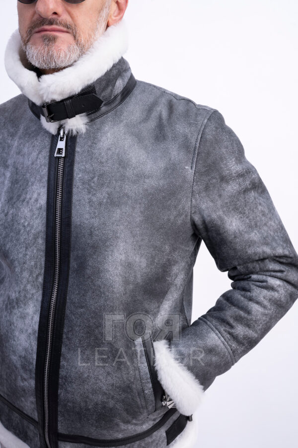 VK- N 85 | ЦВЯТ: Сив Мъжки авиаторски кожух от ГОЯ Leather.  Това е кожух, неподвластен на времето, предпочитан от мъжете заради лесното съчетаване с облеклото в ежедневието. Лек, топъл и комфортен, този модел е чудесен избор за студени зимни дни! Изработен от естествена агнешка  кожа с покритие, този модел не само се отличава със стилен външен вид, но и предлага отлични защитни свойства. Този кожух се съчетава перфектно както с класически, така и с по-спортни дрехи, което го прави универсална дреха. Не пропускайте възможността да добавите този стилен и практичен модел към гардероба си, който ще подчертае вашата индивидуалност и ще осигури комфорт при всяко време. Палтото от овча кожа се закопчава с цип по цялата дължина (70 см). Простият, прав силует на кожуха е допълнен от дизайнерски акценти под формата на контрастни кожени елементи и метални катарами в авиаторски стил.