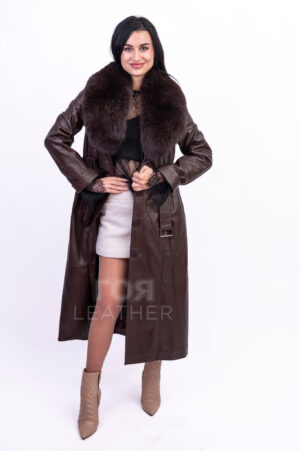 VK- R 56 | ЦВЯТ: Кафяв Новият ни модел кожено манто VK- R 56 | ЦВЯТ: Кафяв  ще осигури на притежателката си несравнима привлекателност. Изработено от мека, висококачествена агнешка кожа, то вдъхва усещане за лукс и увереност във всяко движение. Меката текстура на материала осигурява перфектно прилягане, подчертавайки фигурата ви и позволявайки ви да се движите свободно. Особено впечатляваща характеристика е обемната, подвижна яка, изработена от естествена лисича кожа. Тя не само добавя изтънченост към визията, но и осигурява допълнителна защита от атмосферните условия в по-хладните дни. С едно лесно движение на китката яката може да се отдели, превръщайки палтото в по-семпъл вариант за по-топло време.  За подчертаване на талията има колан с катарама. Дължината  от 128 см. създава  перфектен силует на фигурата. Уникалният цвят  придава на това палто изисканост и класа.