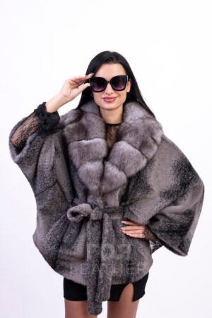 Пончо от алкантара с яка лисица MA- 12 | ЦВЯТ: Сив меланж Всяка дама ще се радва да притежава пончо от алканатара  в гардероба си. Това е стилна дреха, която подчертава предимствата на фигурата и маскира недостатъците, и най-вече не ограничава движенията. Тази материя лесно се справя с капризите на времето. Мека и равномерна, тя задържа топлината вътре, не пропускайки студа. Богатата шал яка от лисица добавя лукс към визията. Материалът, избран за ушиване на продукта, е висококачествена еко кожа в сив меланж. Материалът е мек, има привлекателен външен вид и при носене дава приятно усещане за лекота. Друго предимство на този модел е достъпната му цена, като качеството на изделието по никакъв начин не отстъпва на естествените. Алкантара е модерен материал, състоящ се почти изцяло от топла и лека естествена вълна с малко добавяне на еластан за подобряване на свойствата на плата.