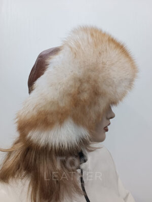 SH- 77 | ЦВЯТ: Светло кафяв Дамска черна шапка с лисица от ГОЯ Leather. Луксозна дамска шапка изработена в комбинация от агнешка напа и лисица. Вътрешна част подплатена с леко ватиран хастар. Универсален размер, с възможност за пристягане в задната част. Цвят на лицевата кожа- светло кафяв. Лисица- светъл пудра цвят в основата и оранжево-червен към върха на косъма.
