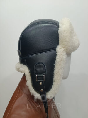 SH- 53 | ЦВЯТ: Черен с бял мутон Кожена шапка ушанка, изработена от агнешка напа в черен цвят и агнешка тула-мутон в бяло ( натурален ). В задната част моделт разполага с катарама за корекция на обема. Вътрешна част ватиран хастар. Моделът е подходящ и за мъже, и за жени.
