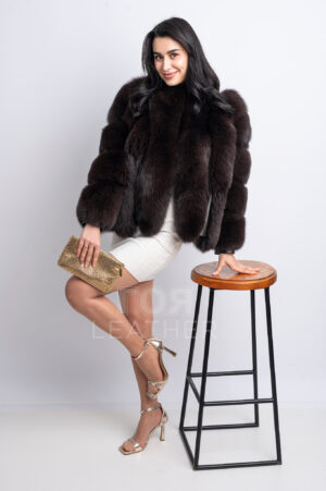 ML-100 | ЦВЯТ: Кафяв Това палто от лисица, артикулен номер ML-100, е луксозен вариант за връхно облекло, който създава изискан и луксозен вид. Изработено е от висококачествена козина от лисица, характеризираща се с гъст, обемен и невероятно мек косъм. Козината е разположена в гъсти, пухкави вертикални редове, създавайки спретната, но силно текстурирана повърхност, която изглежда зашеметяващо при всякаква светлина. Дължината на това палто е 60-65 см, което го прави универсално: може да се носи удобно с панталони, дънки, поли и дори вечерни рокли. Шоколадово кафявият цвят е дълбок, рядък и изискан нюанс, идеален за луксозни зимни визии и визуално подчертава дебелината на козината. Специално внимание заслужава добре обмислената линия на закопчаване: тя е проектирана така, че козината отпред образува плавен преход към обемната яка, създавайки хармоничен вид и визуално удължавайки силуета. Този дизайн подчертава горната част на визията, докато раменете изглеждат женствени и грациозни. Меките ръкави поддържат обем, без да утежняват силуета, създавайки перфектния баланс между комфорт и елегантност. Това палто е стилен и модерен избор за жени, които предпочитат изразителна козина, която веднага ги отличава и повишава статуса им.