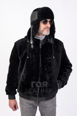 VK- K 21 | ЦВЯТ: Черен Мъжки луксозен кожух-бомбър от агнешки мутон. Ново предложение от ГОЯ Leather в категория мъжки луксозни палта. Моделът с дължина 70см е изработен от висококачествен агнешки мутон в комбинация с агнешка напа. Косъмът на мутона е много мек и лек. Закопчаването с цип осигурява удобно и сигурно прилягане. Подвижната качулка добавя допълнителен комфорт при студените зимни дни. Моделът разполага с два външни и два вътрешни джоба. Ластика в долната част на кожуха и ръкавите е изработен от агнешка напа. Кожуха е изключително удобен и комфортен. Моделът подчертава стилът и класата на своя притежател. За мъжете - ценители на модата и качеството.